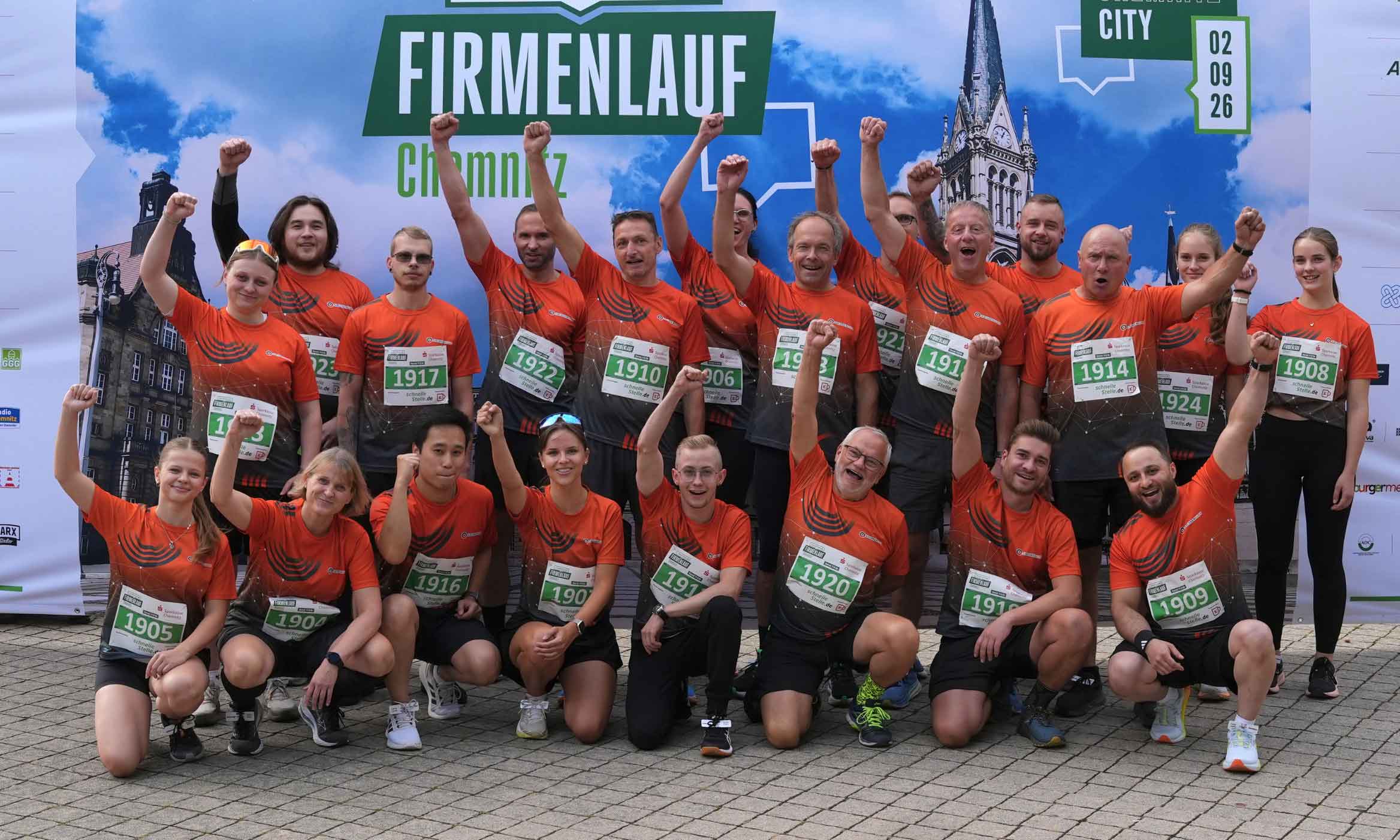 Gruppenbild des Sachsen Guss-Teams beim Firmenlauf Chemnitz 2026. Die Teammitglieder strecken jeweils einen Arm mit geballter Faust in die Höhe.